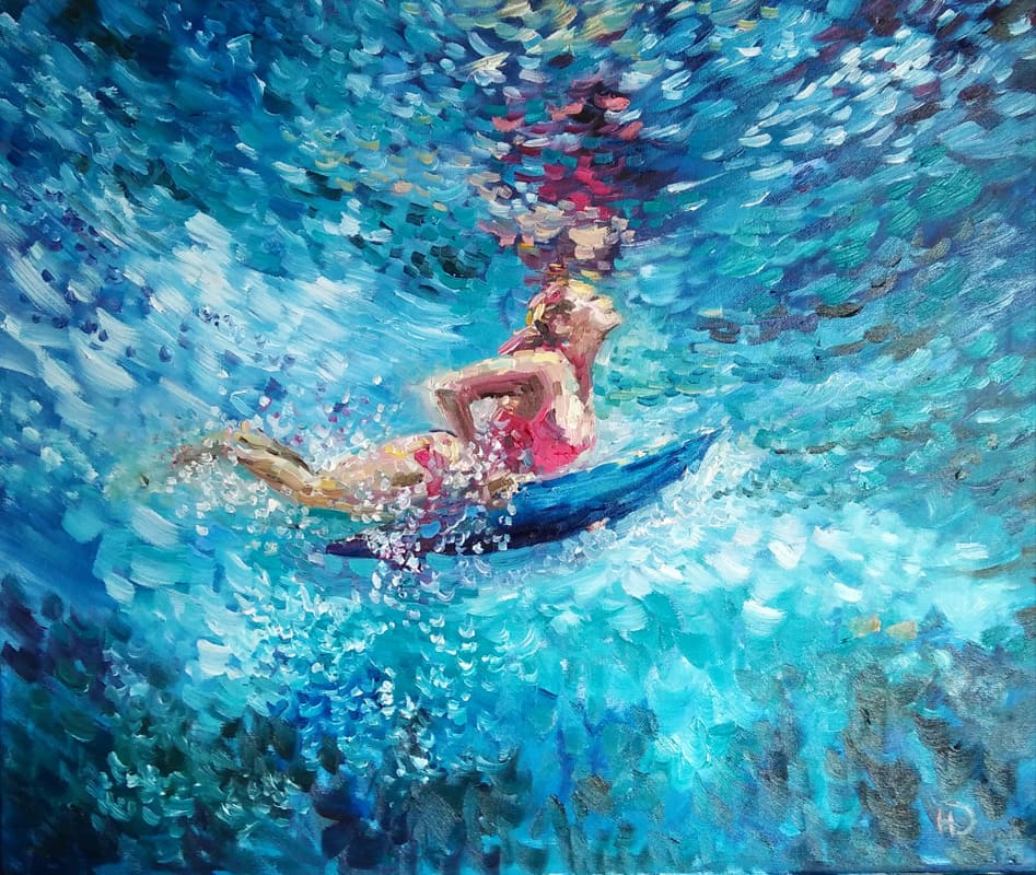 Девышка-сёрфингистка среди переливающихся под солнцем оттенков выныривает из воды - вперед к свету.