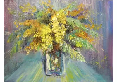 Пушистая мимоза стоит в прозрачной прямоугольной вазе. Весенние цветы отливают золотом.