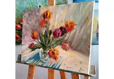 Картина с тюльпанами в вазе на мольберте.