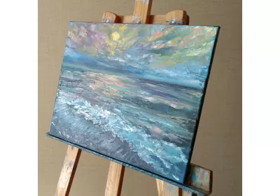 Холст с изображением морского заката на мольберте.